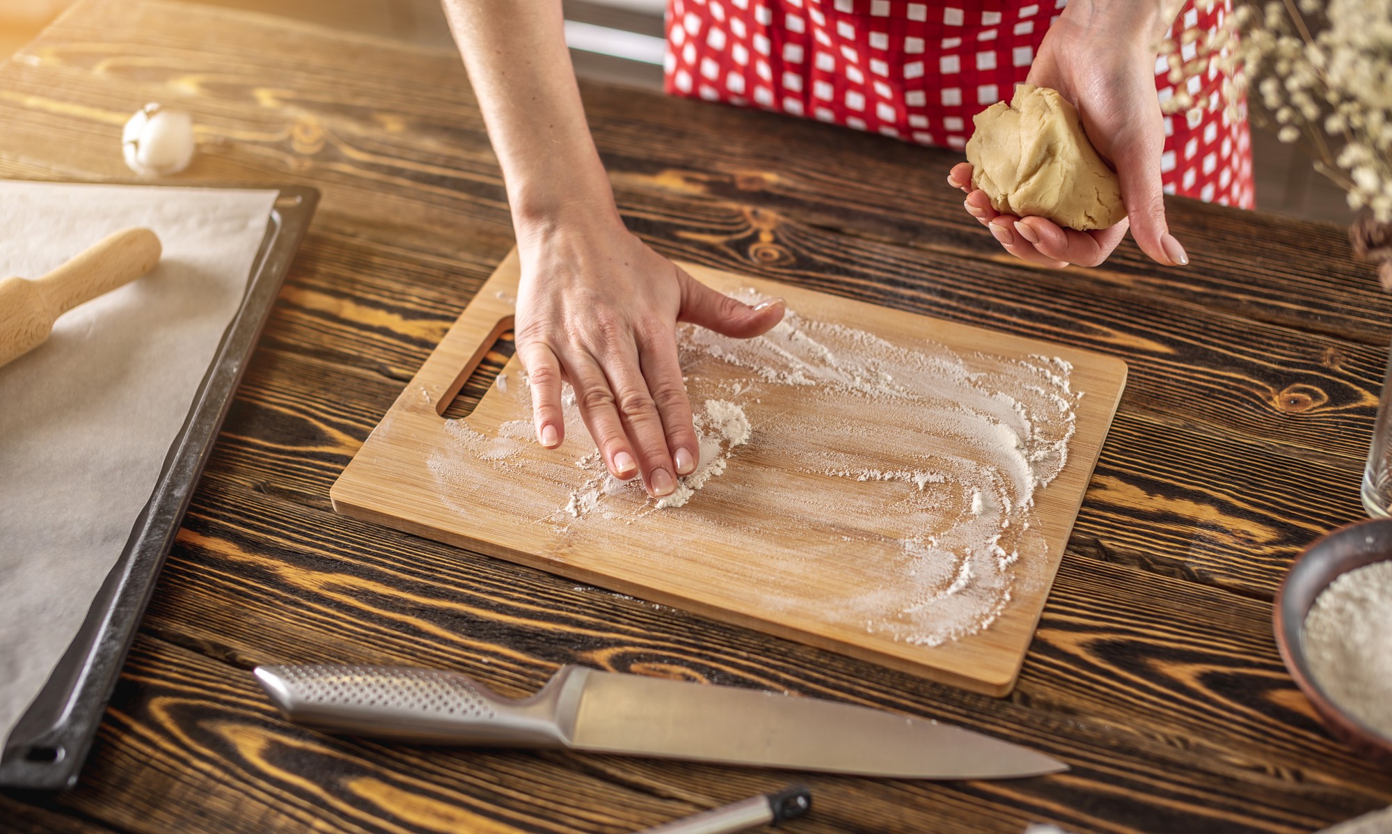 Hands mixing dough on wooden board
